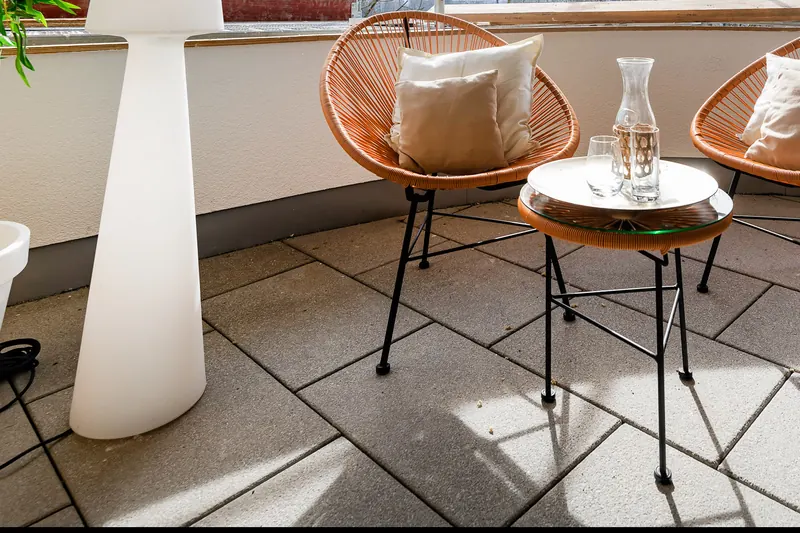 Dachterrasse mit zwei Rattansesseln, Beistelltisch mit Karaffe und Leuchtsäule
